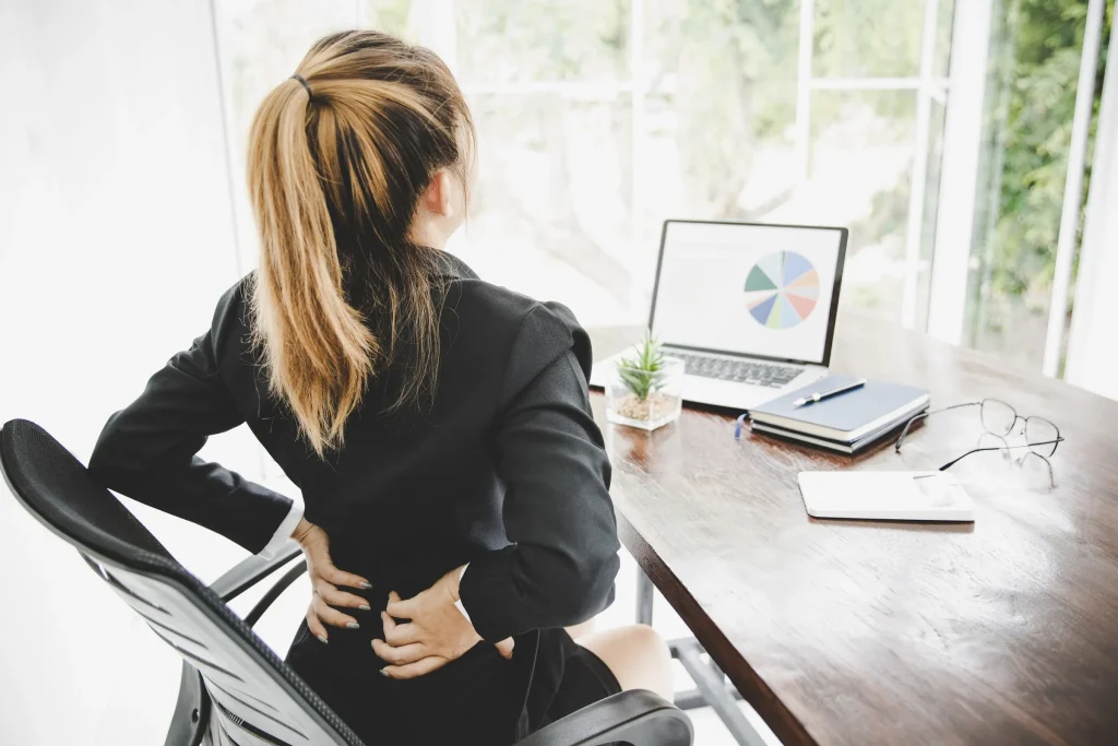 Low back pain at a desk, the posture it most often builds in