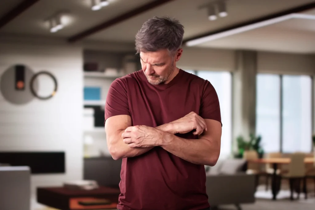 Holding a forearm where radiating pain and tingling are felt