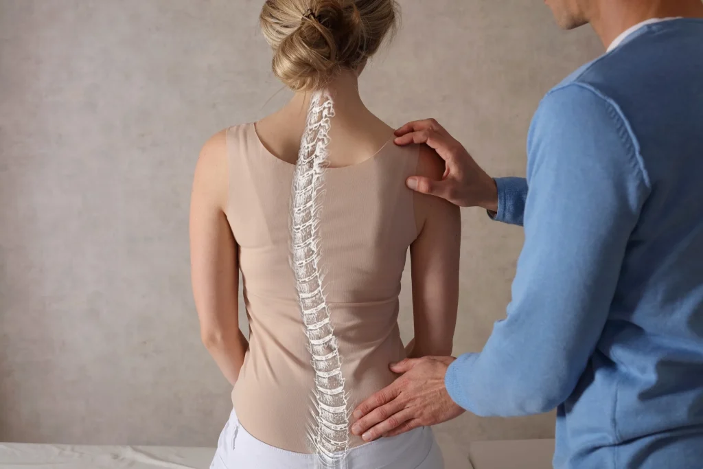 A practitioner assessing the curve of a spine, with the spine highlighted